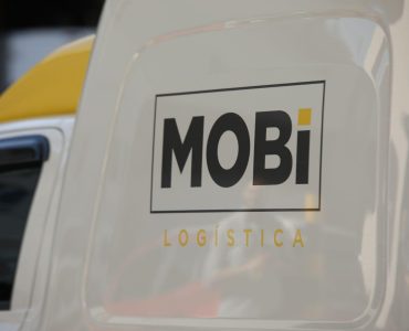 Veículo branco com o logo da Mobi Logística em destaque.