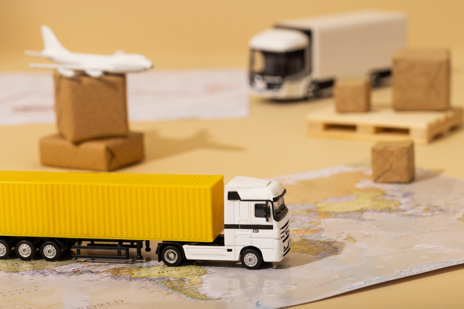 Miniaturas de caminhões, caixas e um avião sobre um mapa.