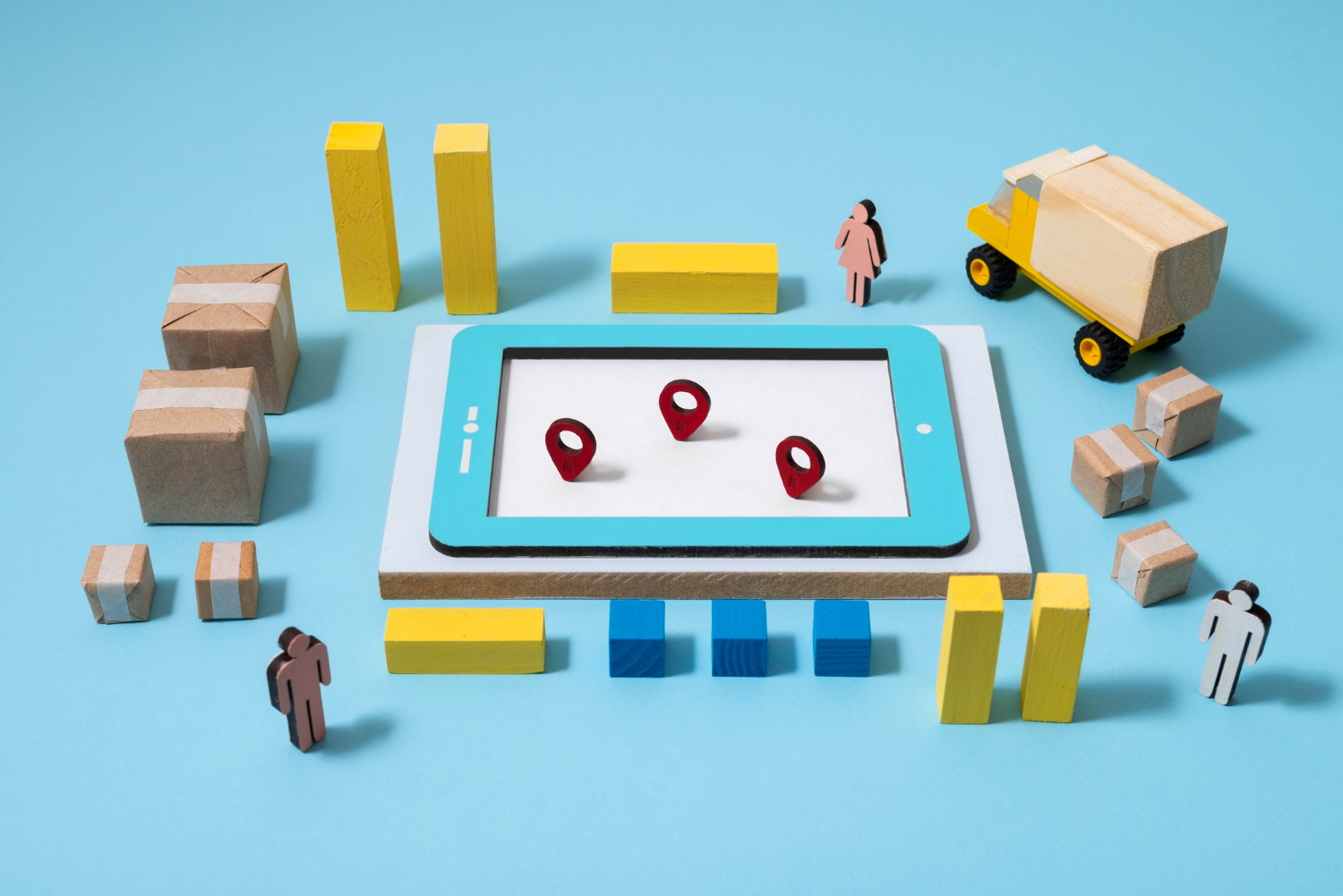 Ilustração que reúne um tablet, algumas caixas e pins de localização, além de um caminhão e algumas pessoas.